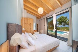 a bedroom with a bed and a large window at Villa Drogarati Cottage by Villa Plus in Chaliotata