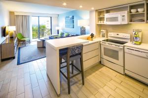 a kitchen with a counter with a bar and a living room at Margaritaville Vacation Club - Rio Mar in Rio Grande +104 photos
