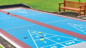 a tennis court with a bench next to a tennis court at Kona Coast Resort in Kailua-Kona