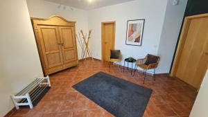 a living room with a wooden cabinet and chairs at Ferienwohnung in der Südheide 