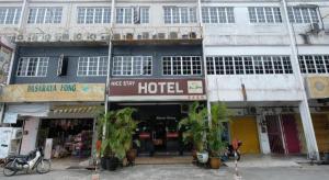 a hotel with plants in front of a building at OYO 1190 Nice Stay hotel in Raub