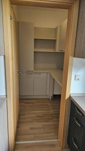 a small kitchen with white cabinets and wooden floors at Ferienwohnung in der Südheide  +1 photo