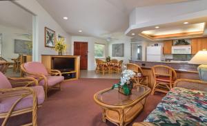 a living room with chairs and a table and a kitchen at Club Wyndham Bali Hai Villas in Princeville