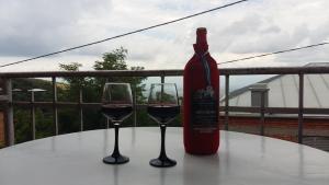 a bottle of wine and two glasses on a table at Tsminda Giorgi Apartment in Sighnaghi
