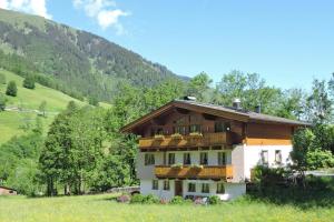 una casa en un campo con montañas al fondo en Apartment in Fusch an der Glocknerstraße in nature, en Fusch an der Glocknerstrasse 42 fotos más