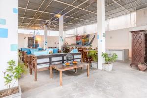 Cette grande chambre comprend une table et des chaises. dans l'établissement Itsy By Treebo - Red Lotus Heritage Promenade Beach, à Pondichéry