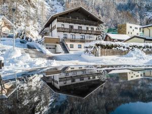 a reflection of a building in the water with snow at Apartment in Sölden near Giggijochbahn in Sölden