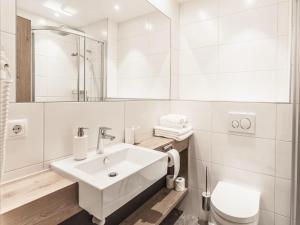 a white bathroom with a sink and a toilet at Apartment in Sölden near Giggijochbahn in Sölden +18 photos