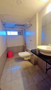 une salle de bain avec un lavabo et des toilettes dans l'établissement Royale Heritage, à Nashik
