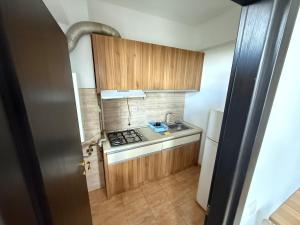 a small kitchen with a stove and a sink at Summerland Flat in Mamaia