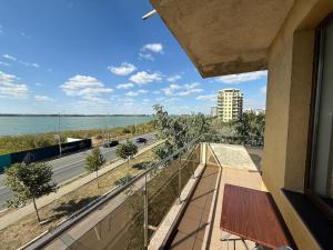 a balcony with a view of a road and water at Summerland Flat in Mamaia
