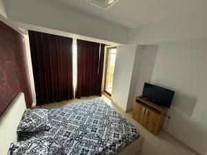 a bedroom with a bed and a flat screen tv at Summerland Flat in Mamaia