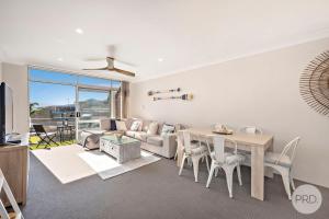 a living room with a table and a couch at Bella Vista Unit 19, 19-21 Shoal Bay Road, Shoal B in Shoal Bay