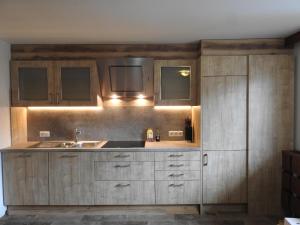 Una cocina con gabinetes de madera y un fregadero. en Chalet in Fügen near Spieljoch Ski Lift, en Fügen