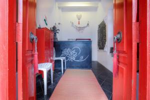 uma porta vermelha com um tapete vermelho num quarto em Itsy By Treebo - Red Lotus Heritage Promenade Beach em Pondicherry