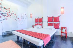 - une chambre avec un grand lit et des oreillers rouges dans l'établissement Itsy By Treebo - Red Lotus Heritage Promenade Beach, à Pondichéry