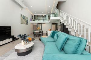 a living room with a blue couch and a staircase at Pool Access Spacious Townhouse and Kids Slide in Koh Samui