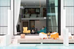 a lobby with chairs and a table in a building at Pool Access Spacious Townhouse and Kids Slide in Koh Samui