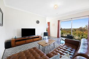 a living room with a couch and a flat screen tv at Gold Coast Family Stay - 4BR Near Theme Parks in Gold Coast +31 photos