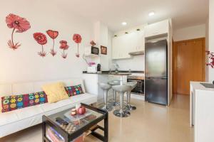 a living room with a white couch and a kitchen at La Cantonada in Sant Pere de Ribes