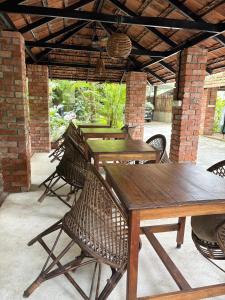 a group of wooden tables and chairs on a patio at Tattwamasi Ayuryoga with Breakfast and Yoga in Varkala