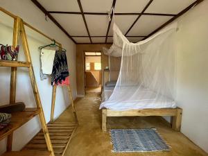a room with a bed with a net on the ceiling at The Shamba in Kilifi