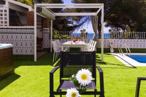a patio with a table and chairs on the grass at Casa MEDITERRANEA in Salou