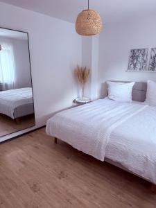 a bedroom with a large white bed and a mirror at R Lodge in Winterberg +16 photos