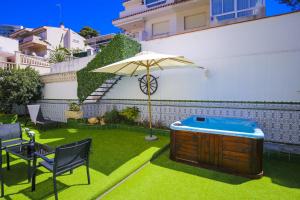 a patio with a hot tub and an umbrella at Casa MEDITERRANEA in Salou
