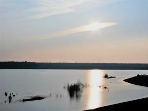 a view of a lake with the sun setting at Ferienwohnung Penthaus ILSE in Großräschen +25 photos