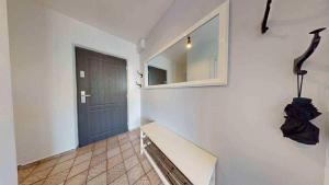 a hallway with a staircase with a door and a mirror at Zlatá Víla by Cañas Apartments V srdci mesta, len pár krokov od hlavného námestia in Rimavská Sobota