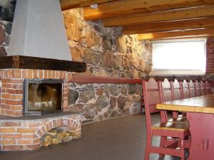 a brick fireplace in a room with a table and chairs at Otepää Apartments in Otepää