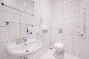 a white bathroom with a sink and a toilet at Pension San Francisco in Vienna