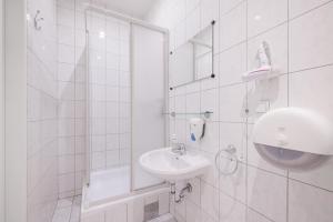 a white bathroom with a sink and a mirror at Pension San Francisco in Vienna