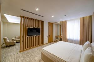 a bedroom with a bed and a flat screen tv at Kamil Palace in Khiva