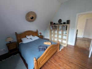 a bedroom with a blue bed and a book shelf at Au Bonheur des Voyageurs, 30' de Paris in Villennes-sur-Seine