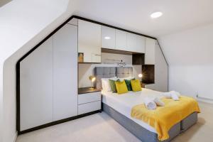 a bedroom with a large bed with yellow pillows at 6 Bedroom 3 Bathroom House in Bicester Village in Bicester