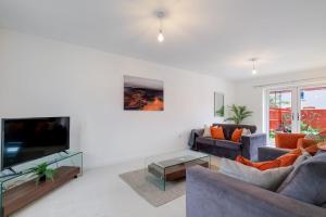 a living room with two couches and a flat screen tv at 6 Bedroom 3 Bathroom House in Bicester Village in Bicester