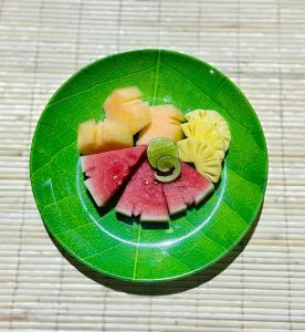 une assiette verte garnie de fruits sur une table dans l'établissement Nusa Dua Huts Pondok Gajah Para by EPS, à Nusa Dua