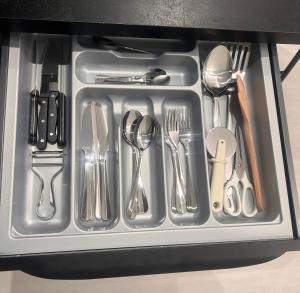 a tray with silver utensils in a drawer at Votre studio exceptionnel à Compiègne in Compiègne