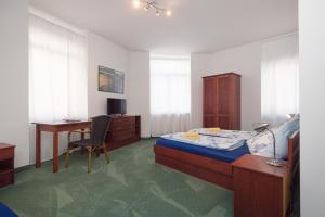 a bedroom with a bed and a desk and a deskablish at Pension San Francisco in Vienna +44 photos