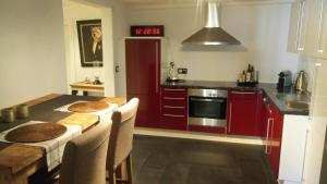 a kitchen with red cabinets and a table with chairs at Stadtblick in Salzburg