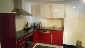 a kitchen with red cabinets and a sink at Stadtblick in Salzburg
