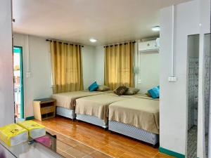 a bedroom with two beds and a mirror at Patcharin Home Stay in Ko Yao Yai