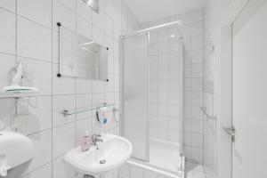 a white bathroom with a sink and a shower at Pension San Francisco in Vienna +44 photos