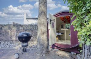 a grill sitting next to a tree next to a wall at FeWo Usedom Karlshagen in Karlshagen