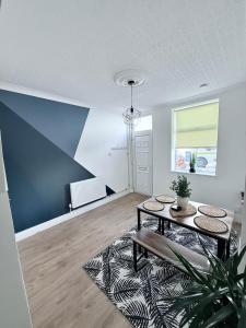 a living room with a table and a blue wall at Seaside Home - Spacious Rooms - TV's in Every Room in Cleethorpes