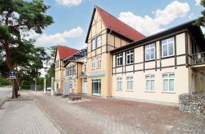a building with a red roof on a street at FeWo Usedom Karlshagen in Karlshagen