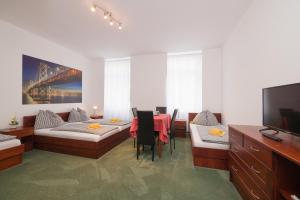 a living room with a table and chairs and a tv at Pension San Francisco in Vienna