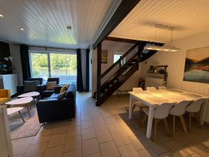 a living room with a table and a dining room at Lakeview Vielsalm in Vielsalm